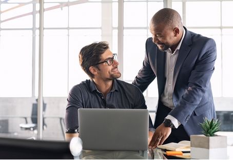 Two colleagues talking at a laptop